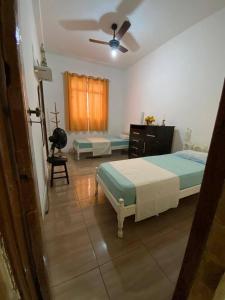 Casa acolhedora e familiar في كامبوس دوس جويتاكازيس: غرفة نوم بسرير وخزانة ومروحة