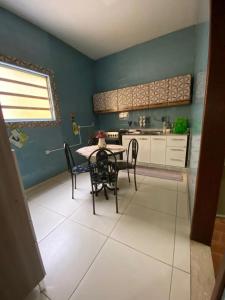 Casa acolhedora e familiar في كامبوس دوس جويتاكازيس: مطبخ مع طاولة وكراسي في غرفة