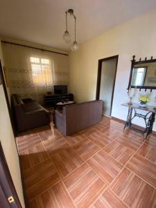uma sala de estar com um sofá e um piso de madeira em Casa acolhedora e familiar em Campos dos Goytacazes