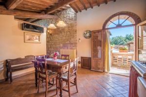 uma cozinha e sala de jantar com uma mesa de madeira e cadeiras em Appartamento il Granaio em Rapolano Terme