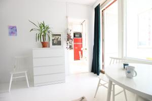 ein Wohnzimmer mit einem weißen Schrank und einem Tisch in der Unterkunft Pasila Studio, Near Expo in Helsinki