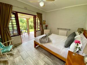a bedroom with a bed and a table and chairs at Berg Escape Kiepersol - Spacious Luxury Family Home in Winterton