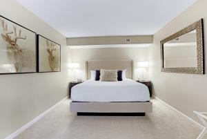 ein Schlafzimmer mit einem weißen Bett und zwei Bildern an der Wand in der Unterkunft The H Hotel in Midland