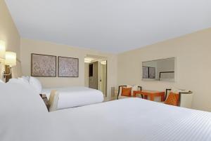 a hotel room with two beds and a table at The H Hotel in Midland