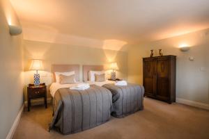 a bedroom with two beds and a table and two lamps at The Loddon Swan in Loddon