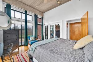 a bedroom with a bed and a dresser and windows at Charming 1BR Condo - Full Kitchen - Uptown Living in Charlotte +37 photos