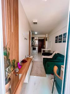 Quarto de Luxo - Saint Moritz في برازيليا: غرفة معيشة مع أريكة خضراء وطاولة