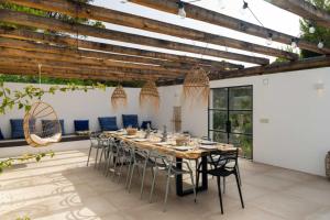 a dining room with a long table and chairs at Molí in Sant Josep de Sa Talaia