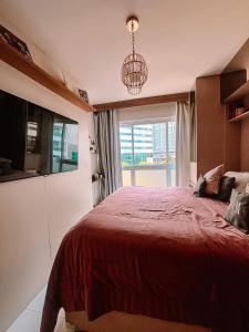 1 dormitorio con 1 cama grande de color rojo y ventana en Quarto de Luxo - Saint Moritz en Brasilia