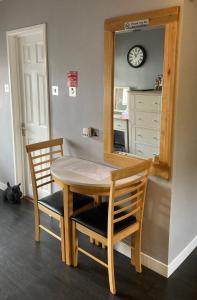 mesa de comedor con 2 sillas y espejo en Twin Gates Annexe, en Falmouth