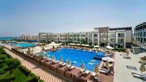 an outdoor swimming pool with chairs and umbrellas at SeaVille Beach Hotel by Elite Hotels & Resorts in Ain Sokhna