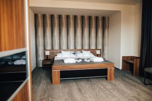 um quarto de hotel com uma cama com almofadas brancas em Hotel Elegance em Šumperk