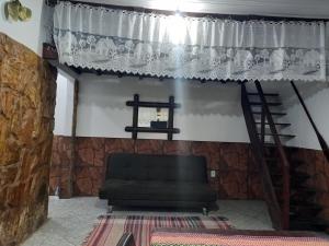 Casas No Saco do Céu في Saco do Ceu: غرفة معيشة مع أريكة وستارة