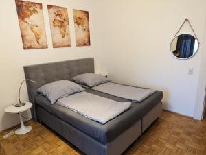 a bed with two pillows and a mirror in a room at Wohnen am Main - gemütlicher Altbau, zentral in Würzburg