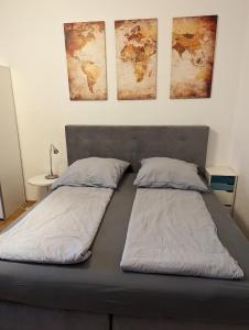 - 2 lits dans une chambre avec des cartes sur le mur dans l'établissement Wohnen am Main - gemütlicher Altbau, zentral, à Wurtzbourg