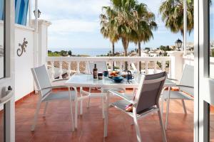una mesa blanca y sillas en un balcón con vistas al océano en Tetuan 11 Oasis Properties, en Nerja