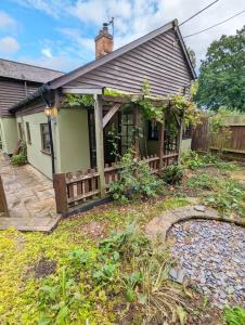 a house with a wooden fence in the yard at 3-Bed, Sleeps 6, 1 Bath, Parking, WiFi in Shalford
