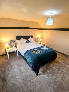 a bedroom with a large bed with a blue blanket at 3-Bed, Sleeps 6, 1 Bath, Parking, WiFi in Shalford