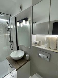 a white bathroom with a sink and a mirror at Apartament 2 camere Mogoșoaia in Mogoşoaia