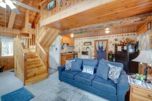 un soggiorno con divano blu in una cabina di Mountain Tops Ponderosa Getaway Near Dome Rock! a Ponderosa