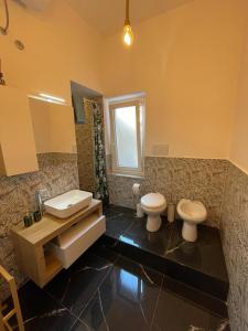 a bathroom with two toilets and a sink at Casetta Beatrice Tivoli Holiday Home (British) in Tivoli