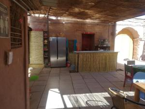 a kitchen with a stainless steel refrigerator in a room at Viajes & Vida km0 in San Pedro de Atacama