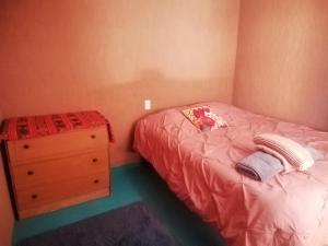 Dormitorio pequeño con cama y vestidor en Viajes & Vida km0, en San Pedro de Atacama