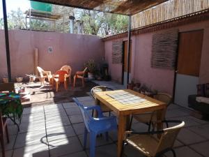 un patio con mesa de madera y sillas en Viajes & Vida km0 en San Pedro de Atacama