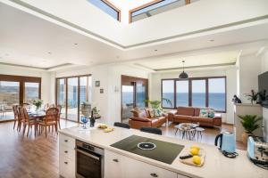een keuken en een woonkamer met uitzicht op de oceaan bij Beachfront Villa Atalandia with Heated Pool, Gym, BBQ & Office in Goúdhouros