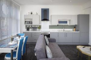 a living room and kitchen with a couch and a table at South Pier Apartments by Sasco in Blackpool