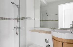 a white bathroom with a sink and a shower at Luxury 1Bedroom Apartment in Singapore! in Singapore