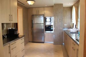 a kitchen with a stainless steel refrigerator and a sink at Royal Villas with private pool in Four-Season Sharm - By Royal Vacations EG in Sharm El Sheikh