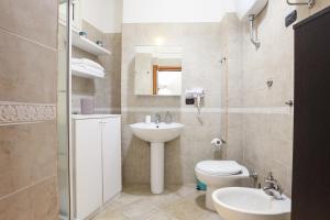 ein Badezimmer mit einem Waschbecken, einem WC und einem Spiegel in der Unterkunft SAN MARCO 13 l t in Neapel