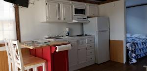 a small kitchen with white cabinets and a white refrigerator at Old Wooden Bridge Resort & Marina in Big Pine Key