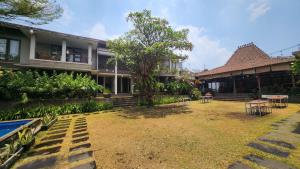 a courtyard of a building with tables and chairs at Summer Hills Hotel & Villas Bandung in Bandung