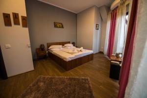 Habitación pequeña con 1 cama y 2 alfombras en Corner Center Rental, en Buzau