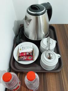 a tray with a tea pot and plates and cups at Solo Nadamax City Guest House Syariah in Bonorejo