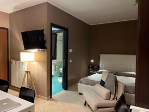 1 dormitorio con 1 cama, 1 silla y TV en MyBed, en Cavallino di Lecce