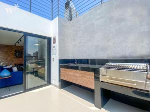 una cocina con barra y parrilla. en Solar by Wynwood House, en Lima