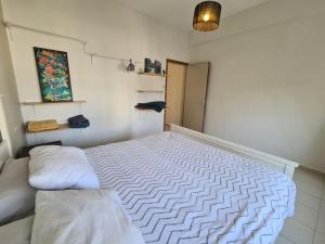 a small bedroom with a white bed with a pillow at Ben Yehuda Penthouse - פנטהאוז משפחתי מקסים עם גג פרטי וג'קוזי במרכז העיר in Jerusalem