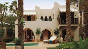 a house with a swimming pool and palm trees at Royal Villas with private pool in Four-Season Sharm - By Royal Vacations EG in Sharm El Sheikh