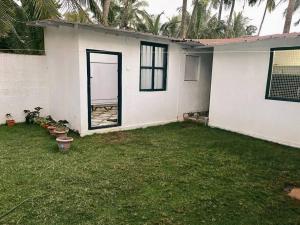 una casa blanca con una puerta en el patio en Fully equipped Beach View House., en Kundapur