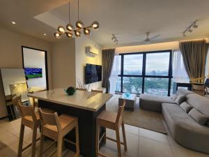 Urban Suite - George Town في Jelutong: مطبخ وغرفة معيشة مع أريكة وطاولة