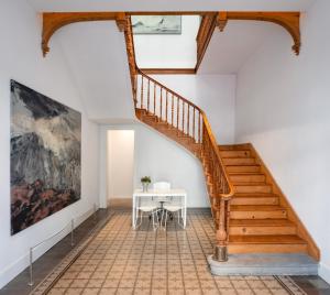 a staircase in a house with a table and a painting at The Park Suites in Santa Cruz de Tenerife