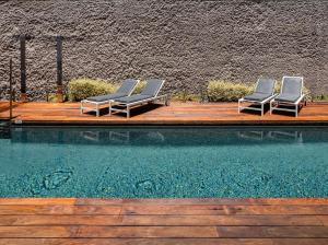 twee ligstoelen naast een zwembad bij The Park Suites in Santa Cruz de Tenerife