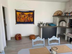 a living room with two chairs and a painting on the wall at Oliver Beach House in Poço da Cruz