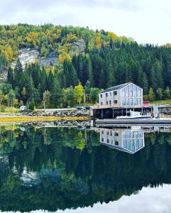 Nordic Waterside Escape في Ulvsvåg: منزل جالس فوق سطح ماء