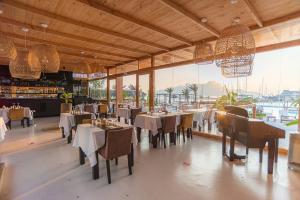 a restaurant with tables and chairs and a large window at Mansa Marina Hotel in Mindelo