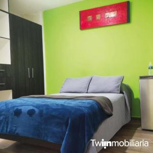 - une chambre dotée d'un lit avec un mur vert dans l'établissement Casa el 9, à Querétaro