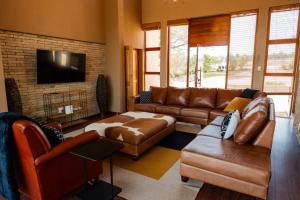 a living room with leather furniture and a flat screen tv at Fourteen Tumbleweed, Cathkin Estates in Ardmore